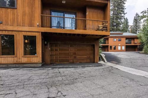 a house with a balcony and a wooden garage at Spacious 3BD & Loft Villa - Convenient to Slopes in Mammoth Lakes