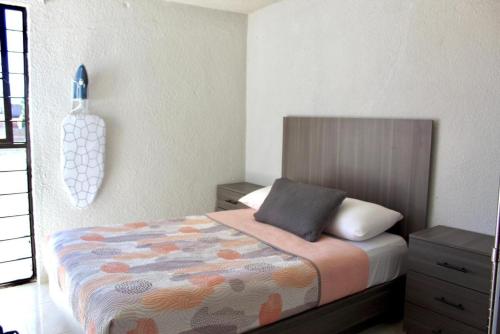 ein Schlafzimmer mit einem Bett und einer Vase an der Wand in der Unterkunft departamento plus 1917 in Zacatlán