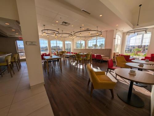 a restaurant with tables and chairs and windows at Hilton Garden Inn Las Vegas Strip South in Las Vegas