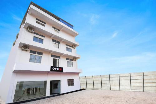 a white building with a sign on it at Hotel O Radha Krishna Residency in Nagri
