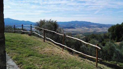 a fence on top of a hill with a view at Colombaio In Colle in SantʼAngelo in Colle