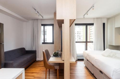 a hotel room with a bed and a couch at Studios Sampa - Vila Buarque - Santa Casa in São Paulo