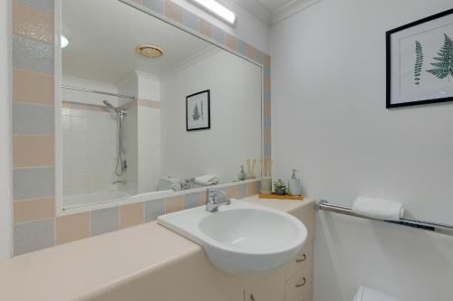 Un baño blanco con lavabo y bañera. en Stylish Studio Escape in the Heart of the GC, en Gold Coast