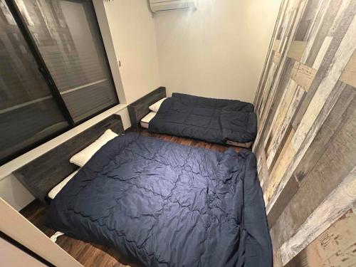 two beds in a room with a window at いすみスローライフ in Chōjamachi