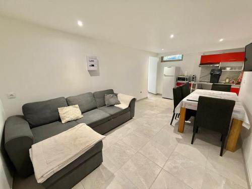 una sala de estar con un sofá y una mesa en Logement en souplexe indépendant dans une propriété, en Castres