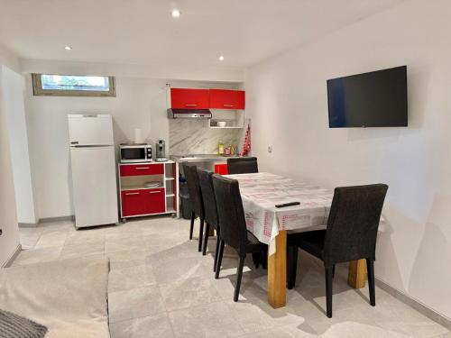 Una cocina con una mesa con sillas y un refrigerador. en Logement en souplexe indépendant dans une propriété, en Castres