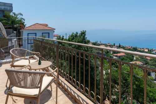 two chairs and a table on a balcony with a view at Trithea Villa in Vlachata