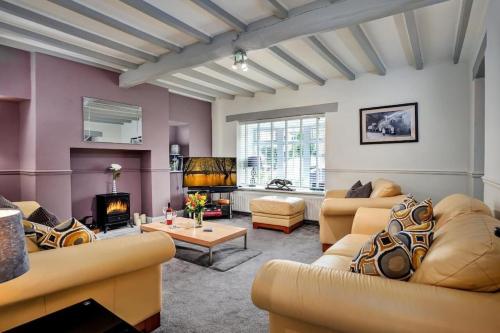 a living room with couches and a fireplace at 3 Bed Cozy Countryside Cottage, Harrogate with Free Parking in Darley