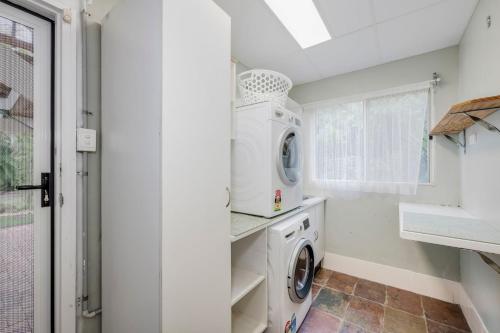 Un lavadero blanco con lavadora y secadora. en 55 See Street Bargara, en Bargara