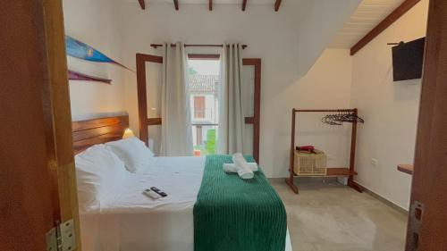 a bedroom with a bed with a green blanket at Casa Vista Verde in Paraty