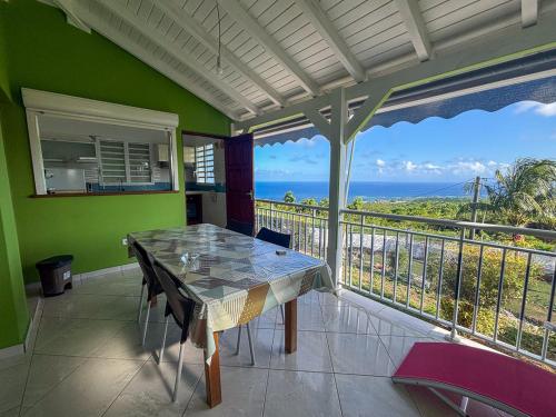 a balcony with a table and a view of the ocean at Gîte Soleil Canne in Capesterre-de-Marie-Galante