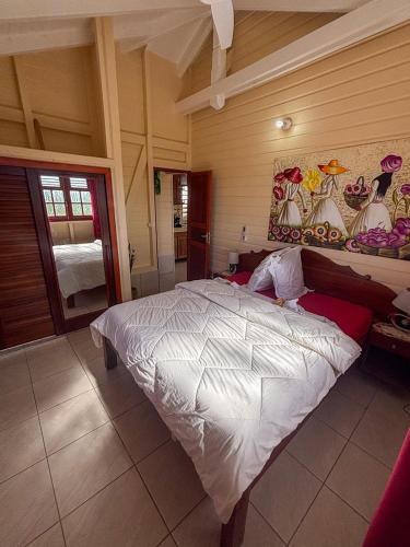 a bedroom with a large white bed in a room at Gîte Soleil Canne in Capesterre