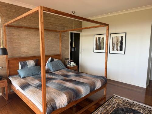 a bedroom with a bed with a wooden frame at Hilltop Getaway in Ocean View