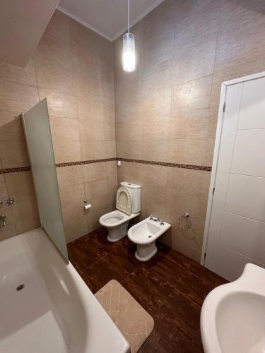a bathroom with a tub and a toilet and a sink at Trainer Center House in Tres Arroyos