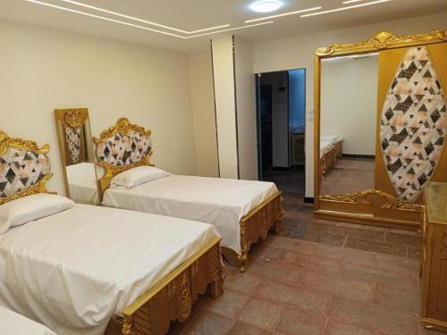 une chambre d'hôtel avec deux lits et un miroir dans l'établissement Elephantine Hotel, à Assouan