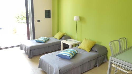Pokój z 2 łóżkami z poduszkami i stołem w obiekcie Appartamento Verde Taormina w Taominie