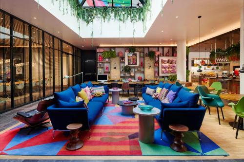 a lobby with blue chairs and a colorful rug at citizenM Miami South Beach in Miami Beach
