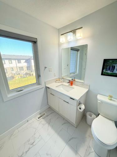 a bathroom with a toilet and a sink and a window at Charming Stay in London in London