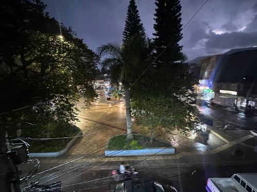 a city street at night with a palm tree at Apartaestudio loft frente al parque Santander in Moniquirá