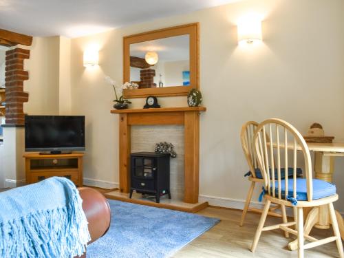 a living room with a fireplace and a mirror at Lower Axford Cottage in Callington