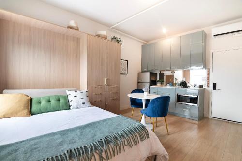 a bedroom with a bed and a table and a kitchen at The Arts in Glendale
