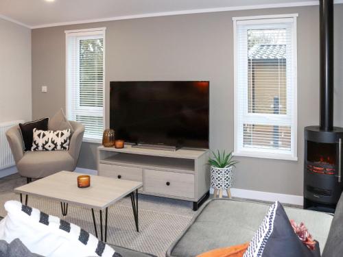a living room with a large flat screen tv at 38 At The Sanctuary Lodges - Uk50850 in Carnguwch