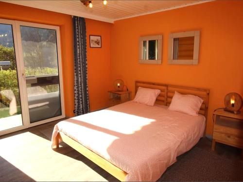um quarto laranja com uma cama e uma janela em Yannsa em Untertweng
