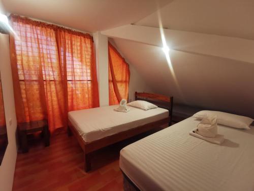two beds in a room with two windows at Latitude 10 Siargao in General Luna