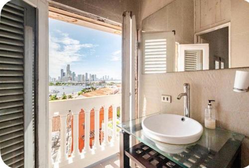 La salle de bains est pourvue d'un lavabo et offre une vue sur la ville. dans l'établissement Apartamento en Cartagena en la Ciudad Amurallada, à Bogotá