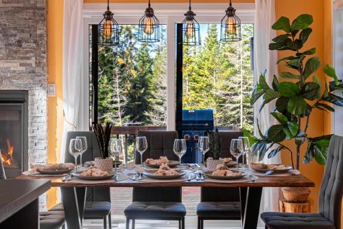 une salle à manger avec une table et des chaises et une cheminée dans l'établissement Boho Vibes Cottage, à Sainte-Lucie-de-Doncaster