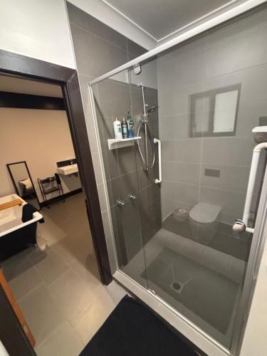 a shower with a glass door in a bathroom at 24 Elizabeth in Oxford Park