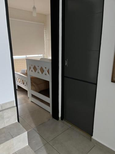 a door leading to a bedroom with a crib at Orillas del Sol Triplex in Chascomús