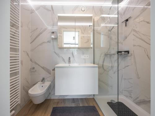 a white bathroom with a sink and a shower at Apartment in Middelkerke with balcony in Middelkerke