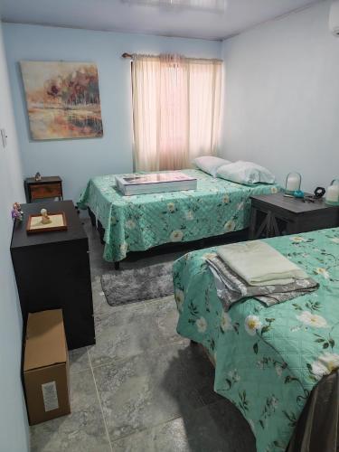 a room with two beds and a table with a mattress at Pequeña Casita Karina in Nicoya