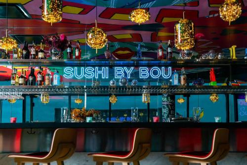 a bar with two chairs and a sign that reads sushi by box at citizenM Washington Capital in Washington