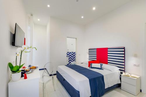 a white room with a bed and a tv at Bellamore in Piano di Sorrento