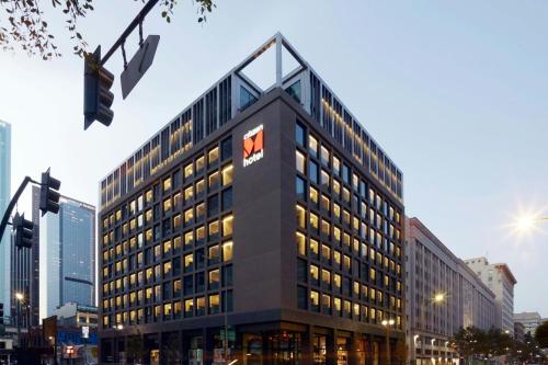 a tall building with a sign on top of it at citizenM Los Angeles Downtown in Los Angeles
