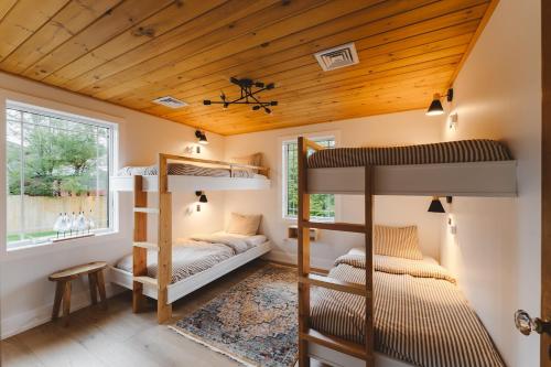 two bunk beds in a room with wooden ceilings at Paddle Point in West Milford