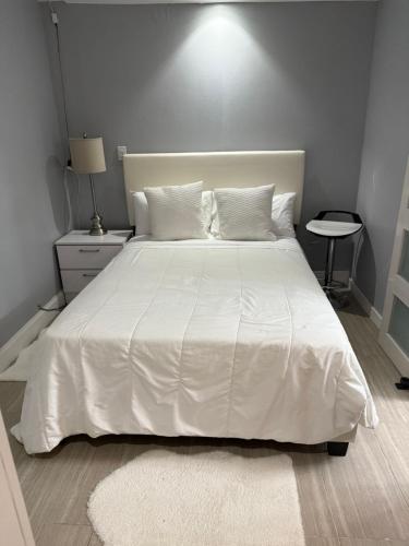 a bedroom with a white bed with a white comforter at Room in Miami