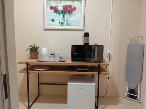 a desk with a microwave and a computer on it at Suíte de Casal Privativa com Sacada in Sao Jose do Rio Preto