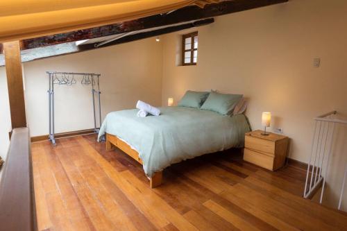 a bedroom with a large bed and a wooden floor at Hermoso Apartamento in Cusco