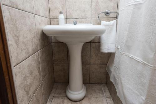 a bathroom with a white sink and towels at Hermoso Apartamento in Cusco