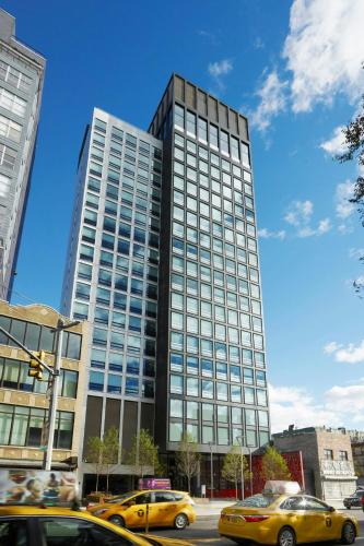 a tall building with cars parked in front of it at citizenM New York Bowery in New York