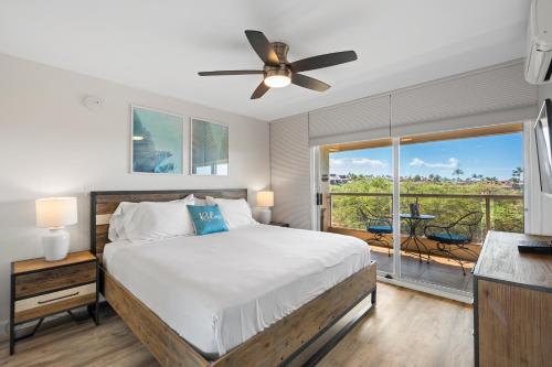 a bedroom with a bed and a large window at Elegant Maui Banyan, Pool, Hot Tub, Across Kamaole II Beach Park in Wailea