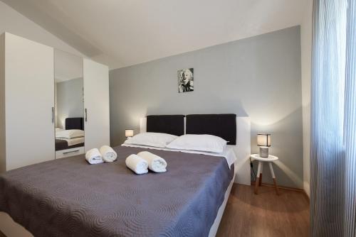 um quarto com uma cama grande com travesseiros brancos em Family-friendly apartments with swimming pool Ljubac, Zadar - 14148 em Krneša
