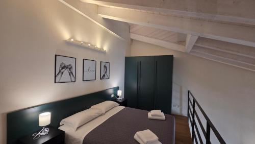 a bedroom with a bed and a black cabinet at BG Suite in Bergamo