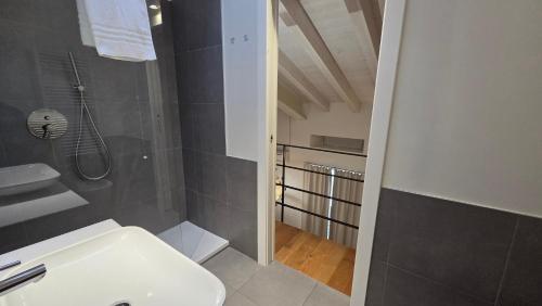 a bathroom with a white sink and a shower at BG Suite in Bergamo