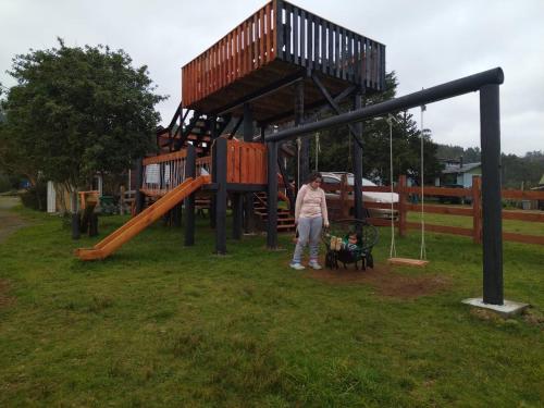 a woman standing in front of a playground at Cabañas francisca in Valdivia