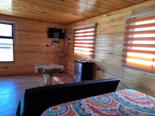 a room with a couch and a table in a room with wooden walls at Cabañas francisca in Valdivia