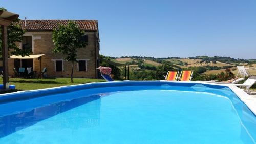 a large blue swimming pool in front of a house at Casa Onda in Senigallia